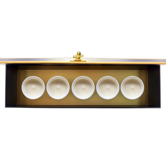 Vue du Coffret Signature Maison Arcane ouvert présentant les cinq bougies parfumées miniatures.