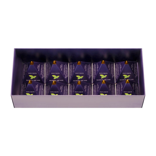 Coffret de thé ouvert Maison Arcane montrant les infusions parfumées dans leur packaging pyramidal à l’intérieur.