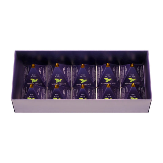 Coffret de thé blanc parfumé ouvert, présentation intérieure de dix infusettes pyramidales Maison Arcane.
