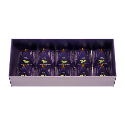 Vue intérieure d’un coffret de thé noir ouvert Maison Arcane avec infusions parfumées dans leur packaging pyramidal à la pointe dorée.