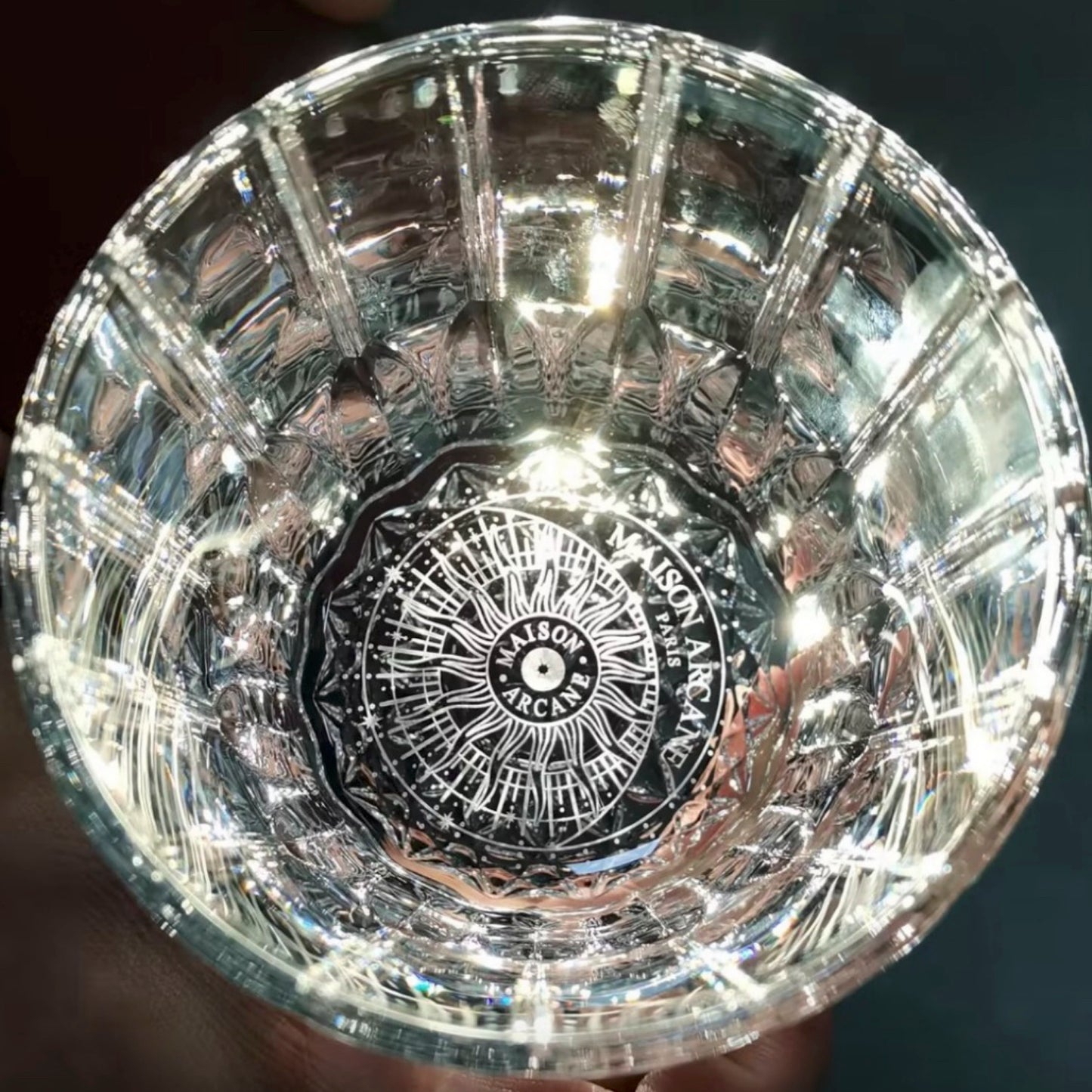 Zoom sur le contenant en cristal Maison Arcane gravé du logo, design raffiné réutilisable comme verre à whisky ou objet décoration.