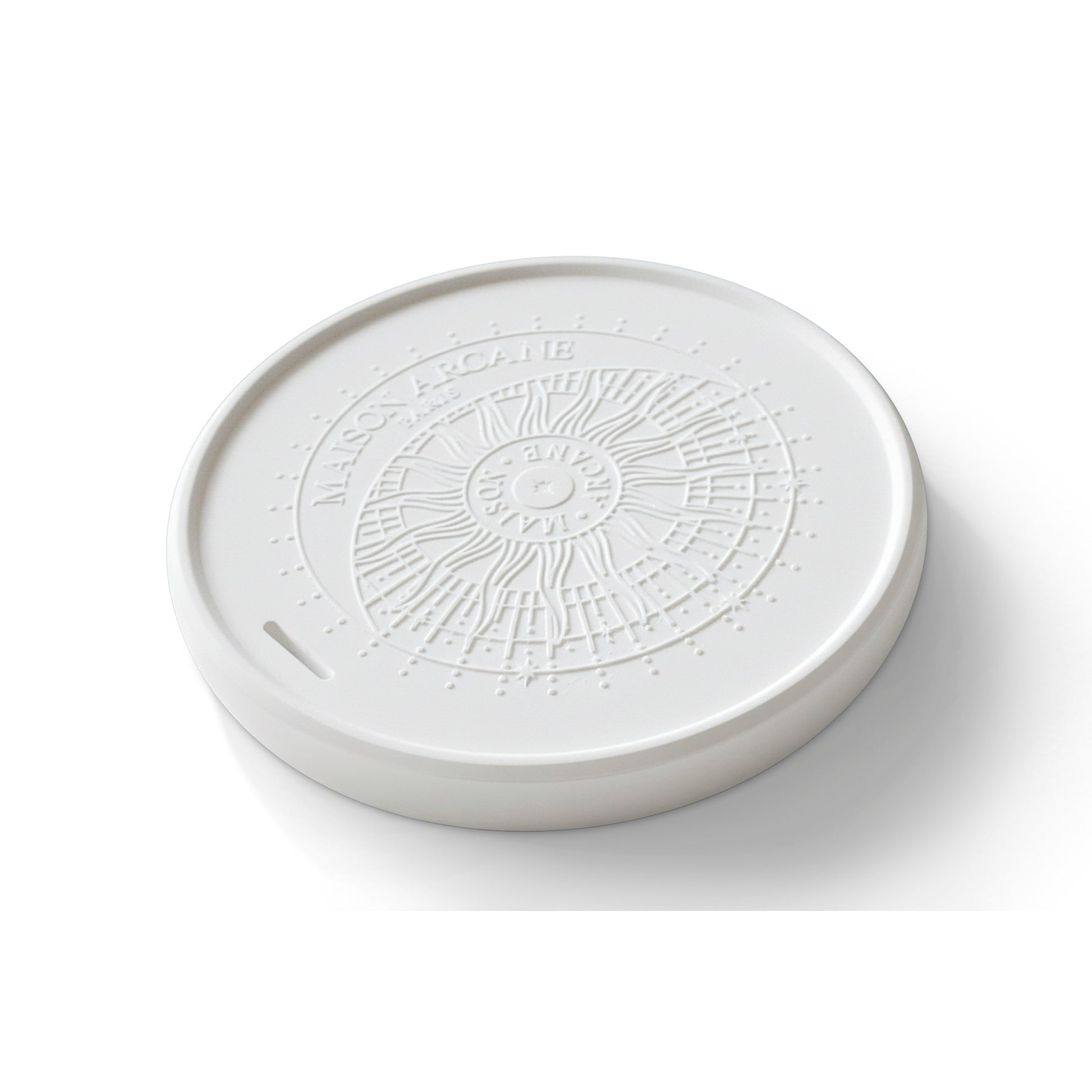 Détail de la surface poreuse de la pierre diffusante avec son logo en relief Maison Arcane, conçue pour retenir et libérer lentement les concentrés de parfum.