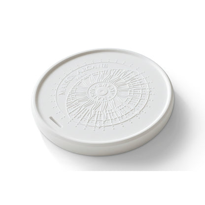 Détail de la surface poreuse de la pierre diffusante avec son logo en relief Maison Arcane, conçue pour retenir et libérer lentement les concentrés de parfum.